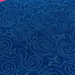 Dark blue backing of Starry Night quilt with scattered aqua speckles and flowing spiral stitching.