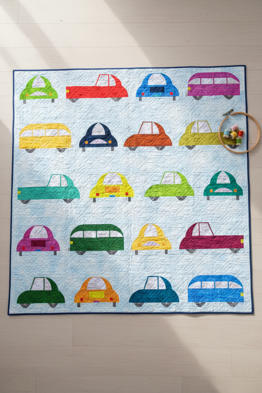 Handmade Cool Cars quilt with colorful car designs laid flat outdoors
