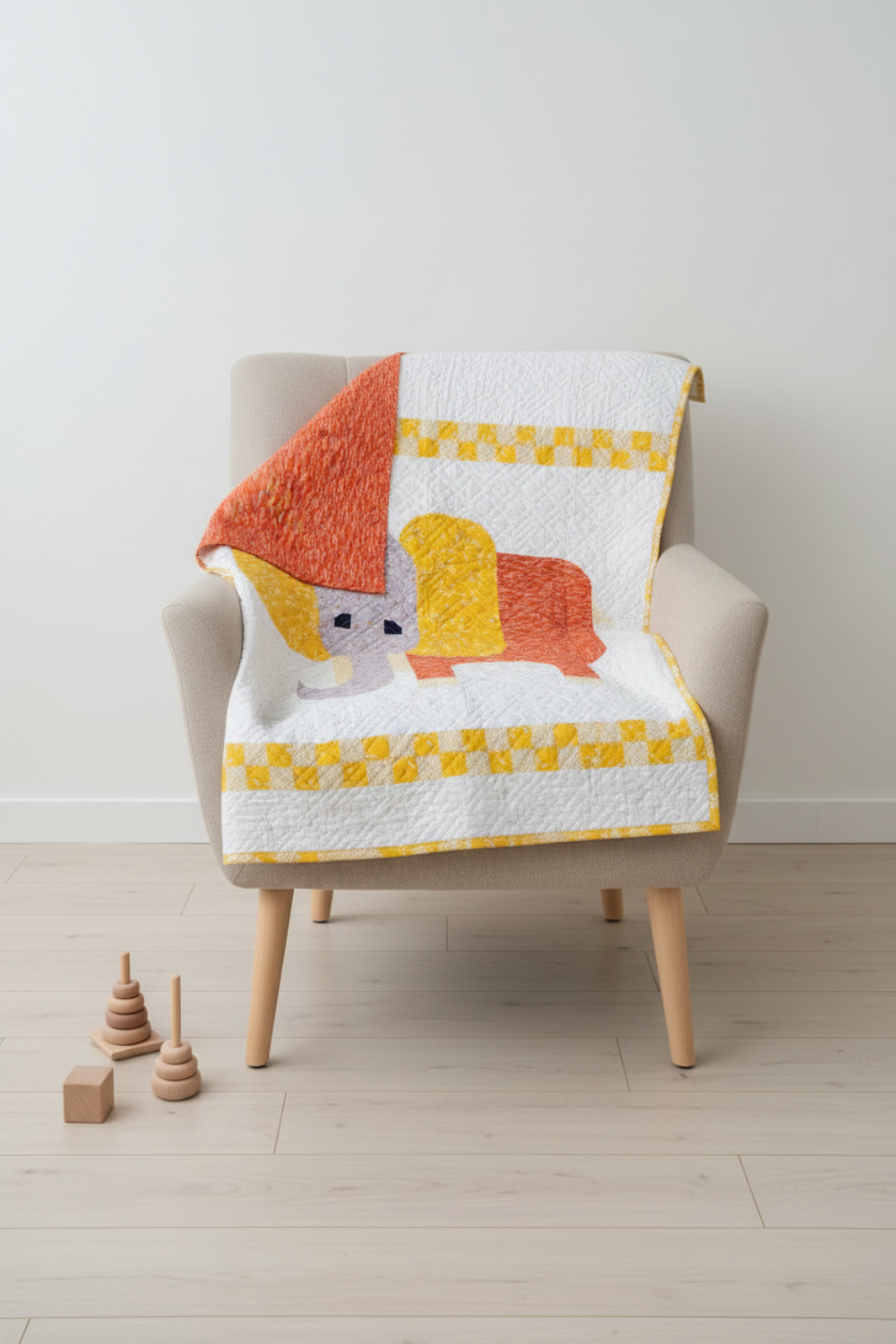 Playful handmade elephant baby quilt in soft yellow, gray, and orange tones