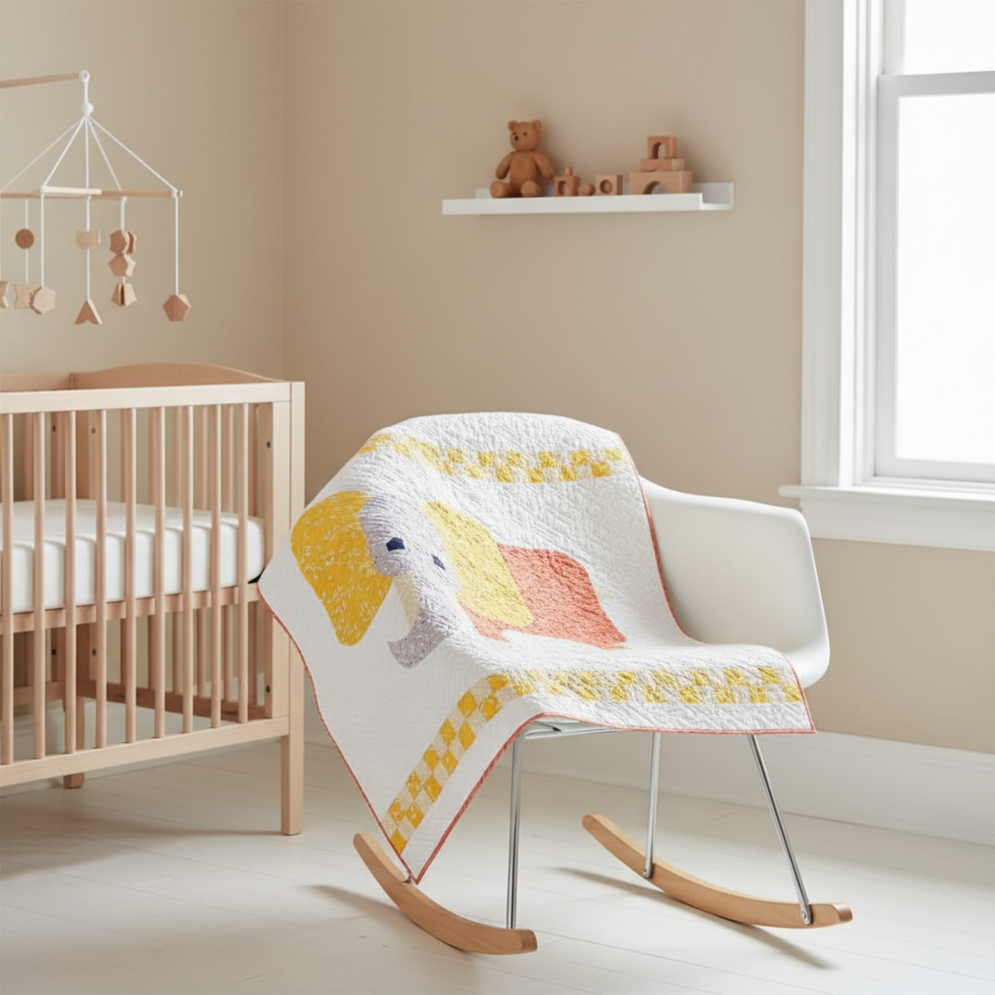 Handmade elephant baby quilt styled in a modern nursery as a cozy lap quilt.
