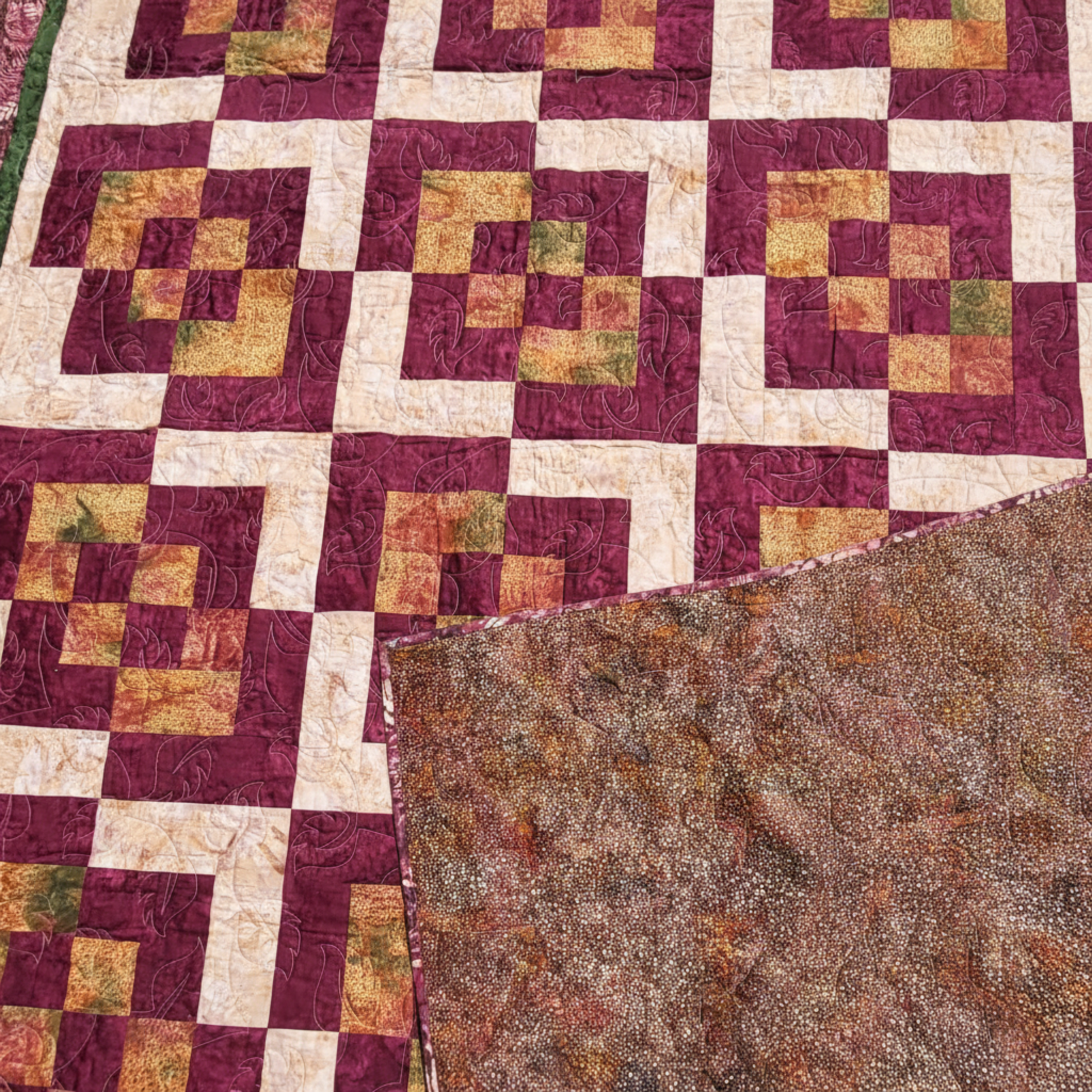 Corner Play quilt showing front geometric design and coordinating batik backing