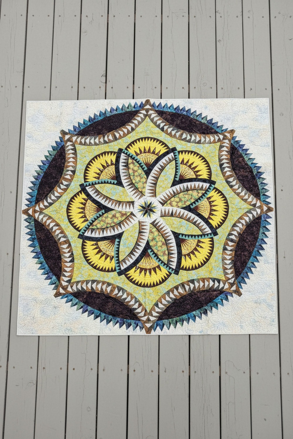 Lily Pond Hosta handmade quilt with intricate batik floral medallion laid flat outdoors