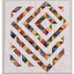 Handmade 4‑Patch Charm quilt in rich batik fabrics, shown flat with colorful four‑patch blocks and soft, swirled quilting.