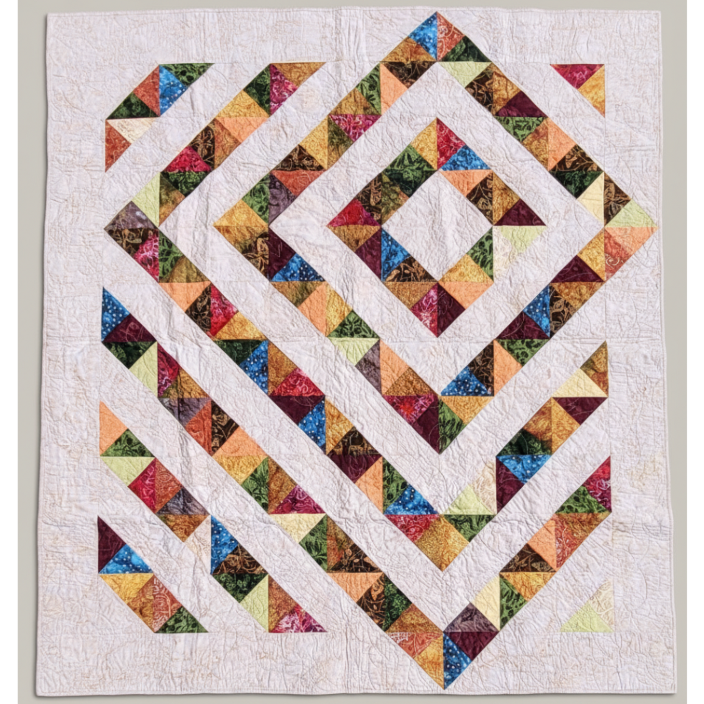 Handmade 4‑Patch Charm quilt in rich batik fabrics, shown flat with colorful four‑patch blocks and soft, swirled quilting.