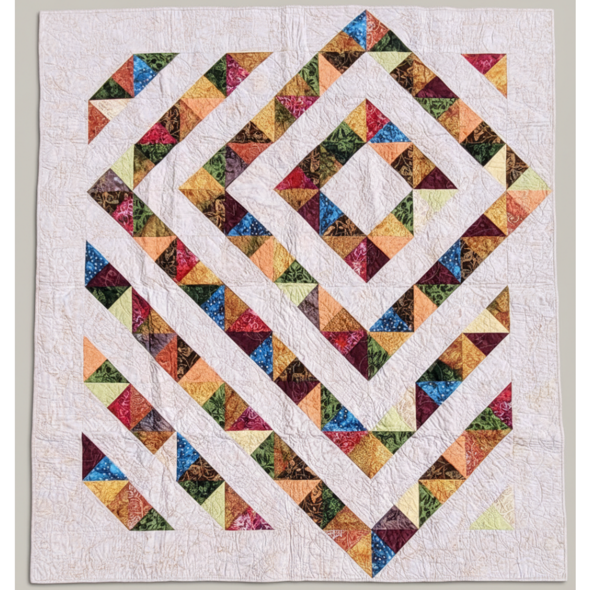 Handmade 4‑Patch Charm quilt in rich batik fabrics, shown flat with colorful four‑patch blocks and soft, swirled quilting.