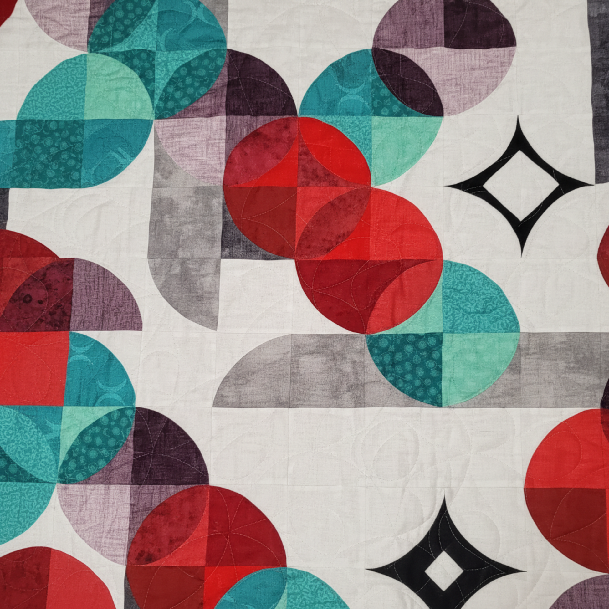 Close-up of circular piecing and swirl quilting on Moon Dance quilt