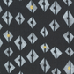 Close-up of Dance in Paris Lanterns Metallic Charcoal fabric, with pale gray split-diamond motifs and occasional gold accents on a charcoal ground.