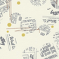 Celestial News Dropping Moonbeam fabric by Zen Chic for Moda Fabrics, featuring charcoal newsprint motifs and mustard-gold dots on ivory, shown vertically with a ruler for scale.