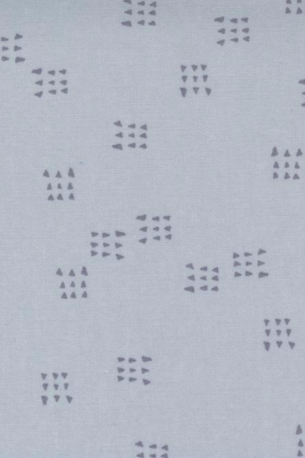 Close-up of Celestial Nine Triangle Stardust fabric by Zen Chic for Moda Fabrics, featuring charcoal nine-triangle clusters on pale blue-gray. 