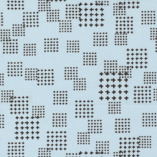 Close-up of Lazy Afternoon Sky Fabric by Zen Chic for Moda Fabrics, showing scattered grids of black cross-shaped marks on a pale blue background.