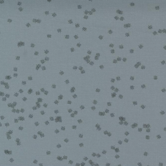 Close-up of Modern Background Even More Paper Steel Crosshatch Bolt B fabric by Zen Chic for Moda Fabrics, with scattered dark crosshatch marks on a muted steel blue-gray background.