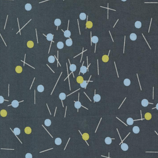 Close-up of Bluish Pins & Buttons Charcoal quilting cotton with scattered pale blue and chartreuse pins on a charcoal background.