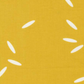 Close-up of Filigree Rice Saffron fabric by Zen Chic for Moda Fabrics showing white rice-grain shapes on a saffron-mustard ground