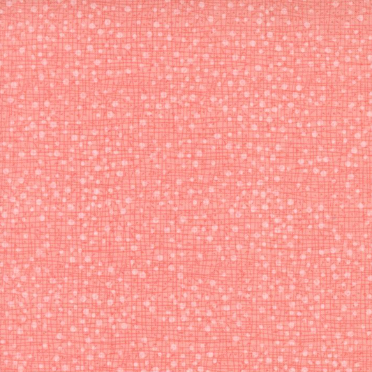 Dotty Thatched Carnation quilting cotton by Robin Pickens for Moda Fabrics — close-up showing the warm coral-pink ground with scattered tonal dots and crosshatch texture detail. 100% cotton. Available at IraRobi Quilts.