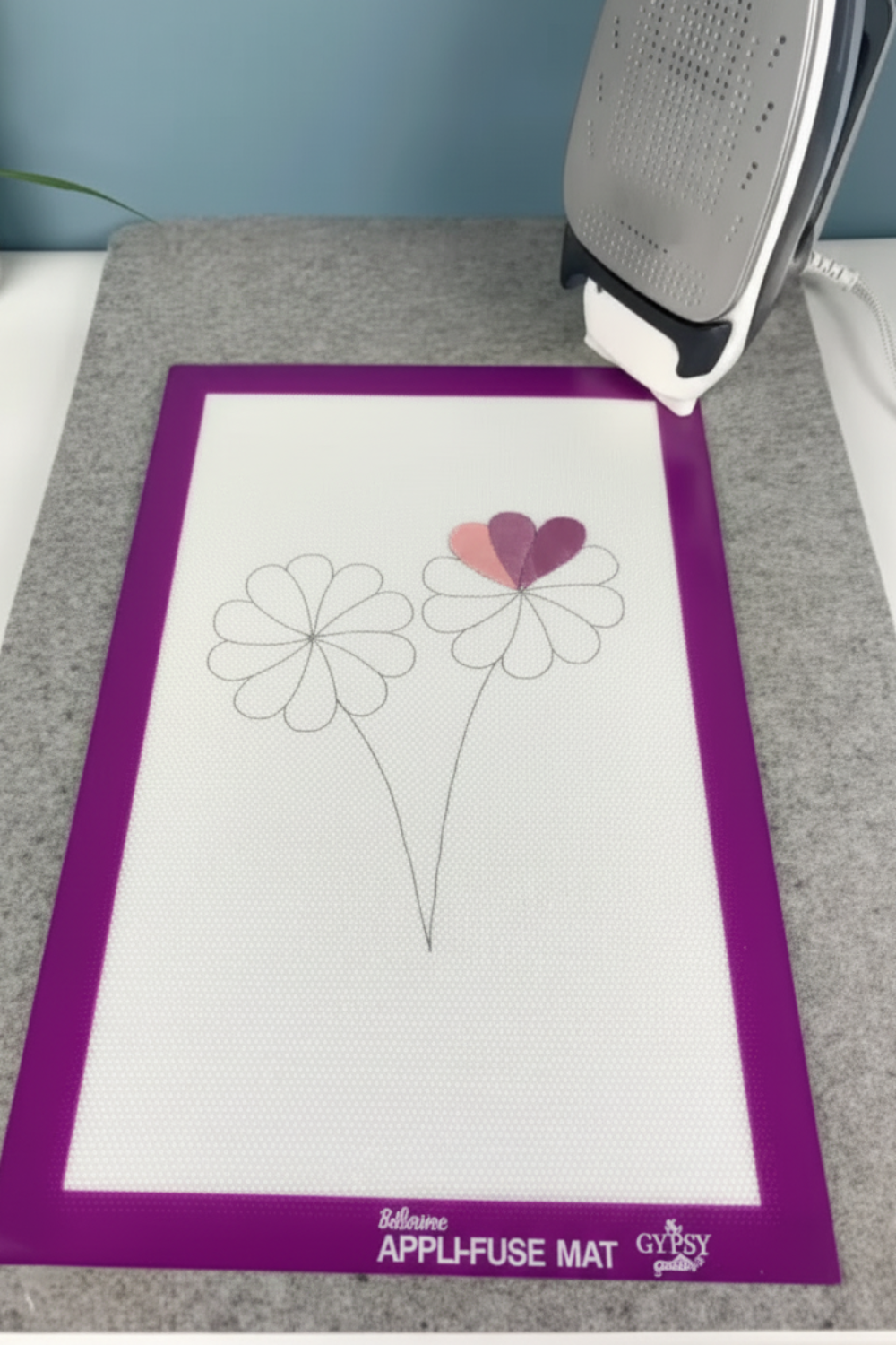 Appliqué placement visible through transparent Silicone Appli-Fuse Mat for precise positioning.