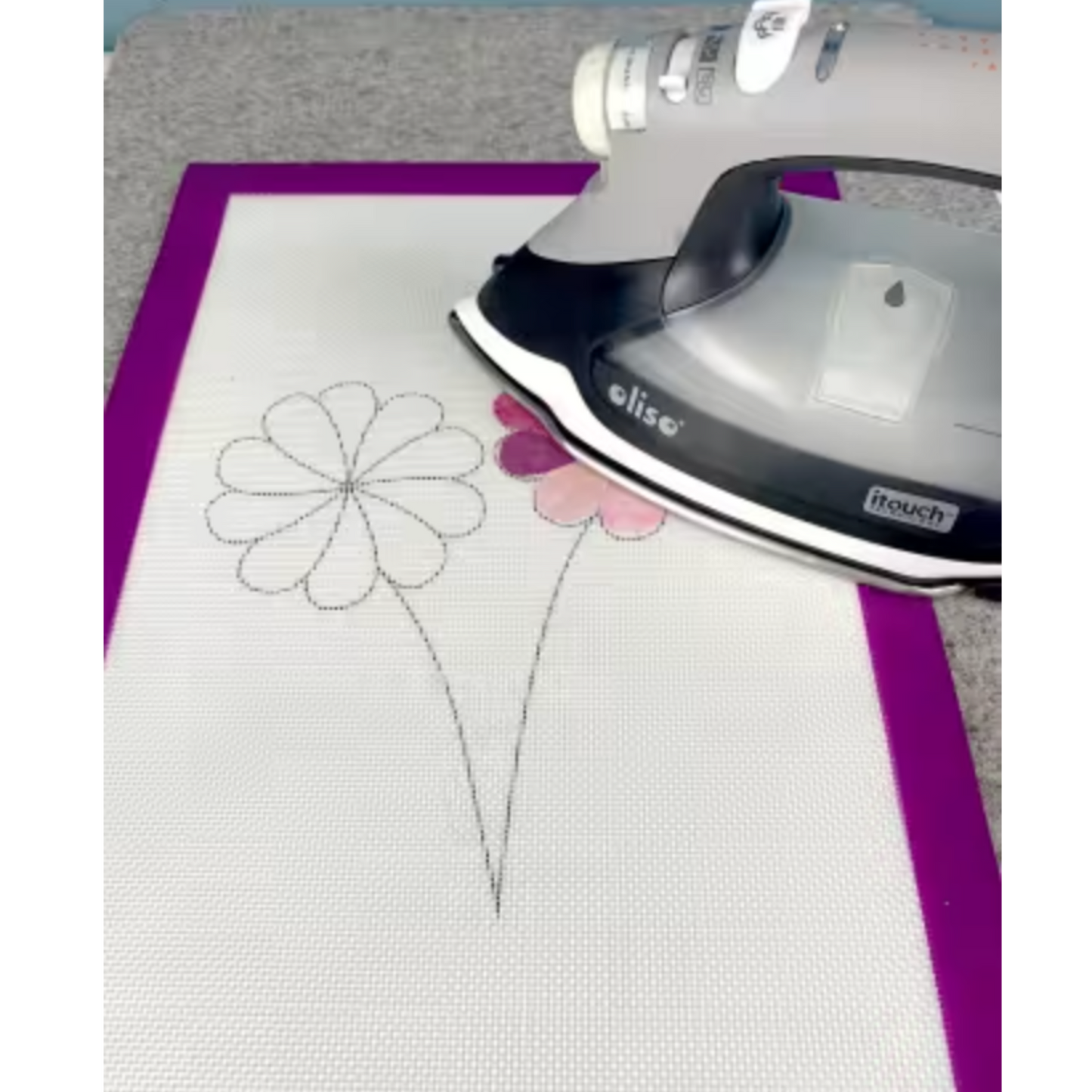 Using an iron on fusible appliqué shapes placed on a Silicone Appli-Fuse Mat during pressing.