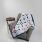 Barn star quilt throw – sampler quilt draped over chair in modern home setting