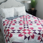 Barn star quilt bed design – pink and purple star sampler quilt on bed
