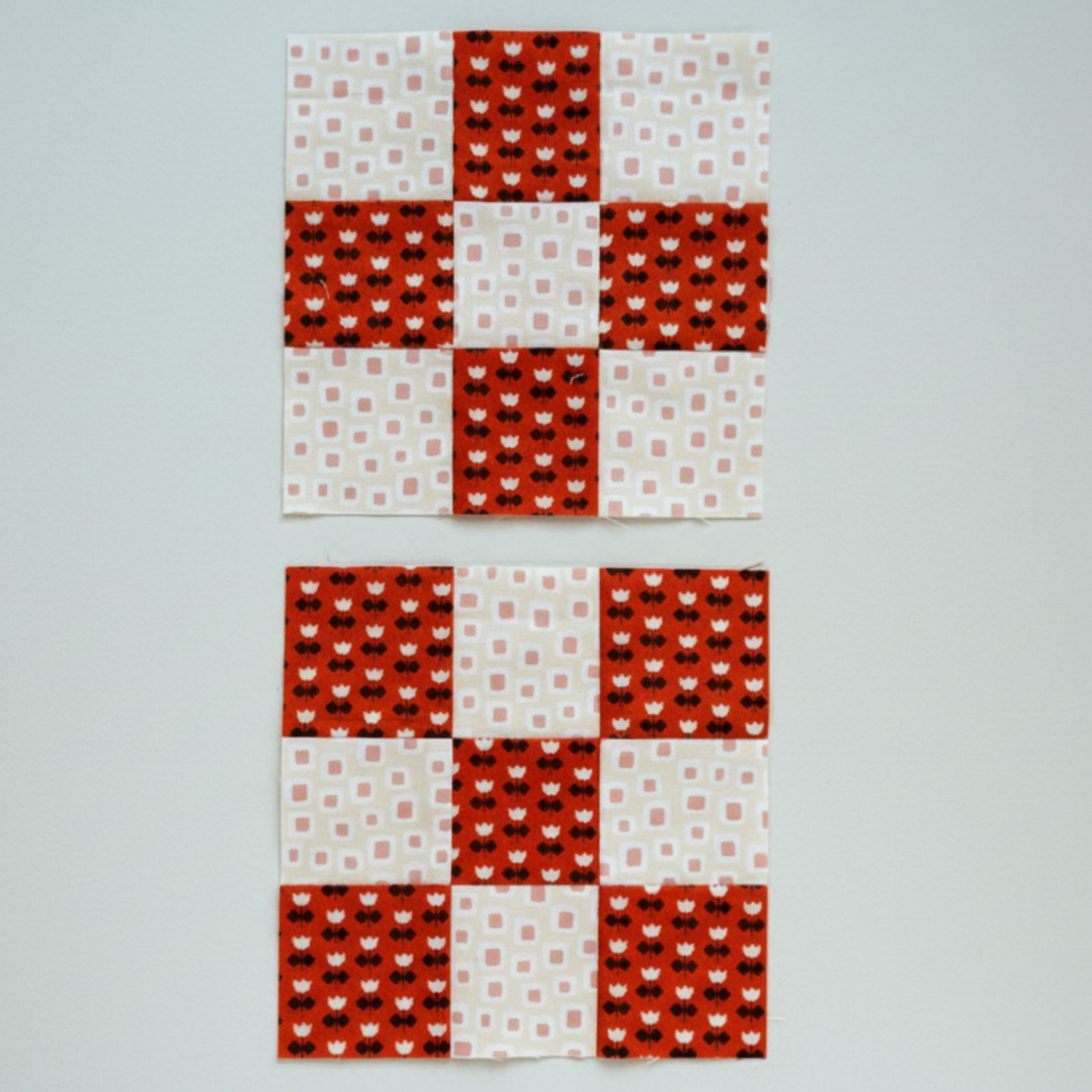 Nine patch quilt block layout – red and cream fabric squares arranged in classic patchwork design