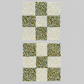 Fabric strips arranged for nine patch quilting – green and white patterned pieces ready for sewing