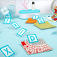 AlphaClippies quilt organization clips displayed on sewing table with fabric squares and quilting accessories