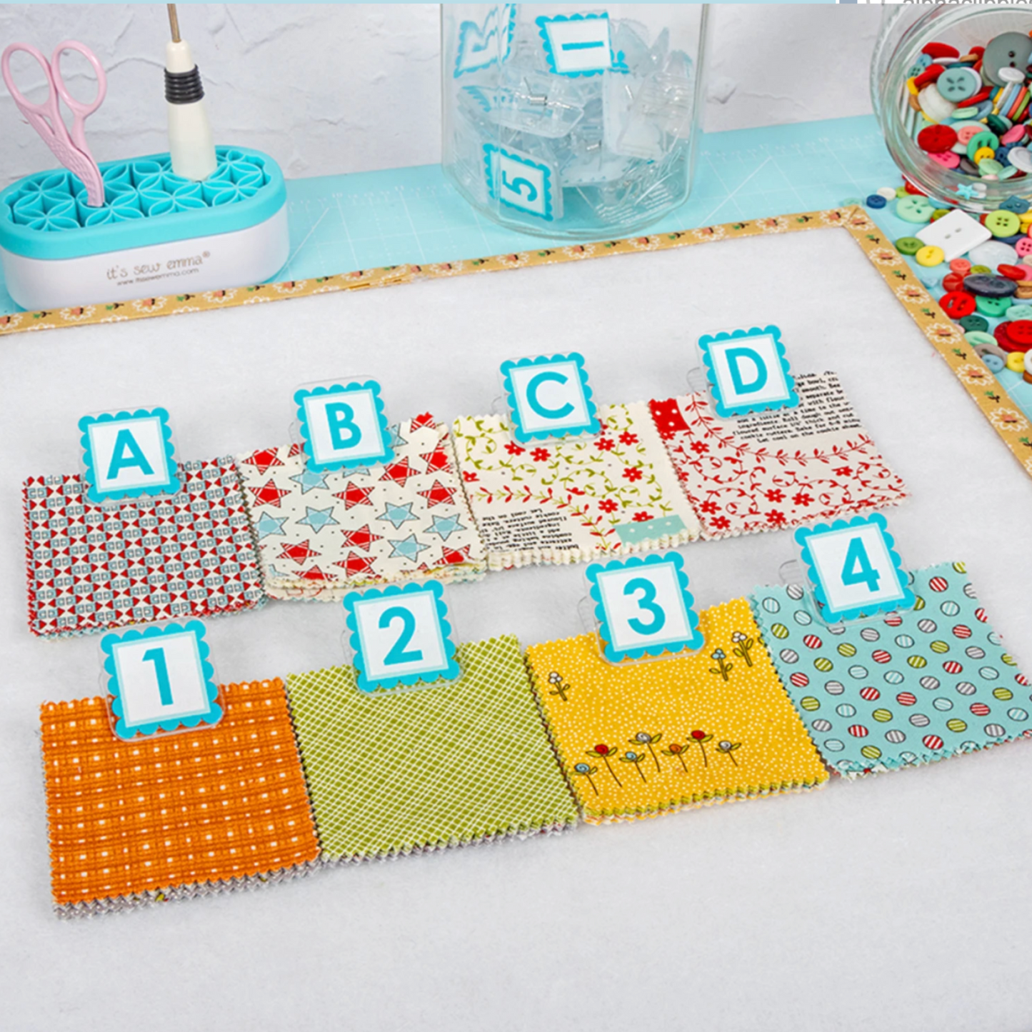 AlphaClippies alphabet and number marking clips organizing fabric swatches on quilting design board workspace
