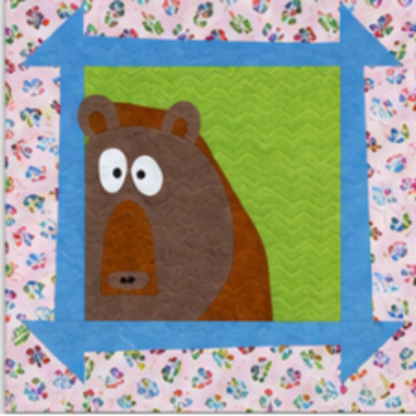 Bear applique quilt block with brown bear design in blue arrow border and floral print background quilt square