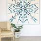 Blue and white Northern Lights quilt hanging on wall in modern room with chair and potted plant