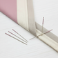 Lori Holt binding needles with pink eyes used for hand-stitched quilt binding on folded fabric