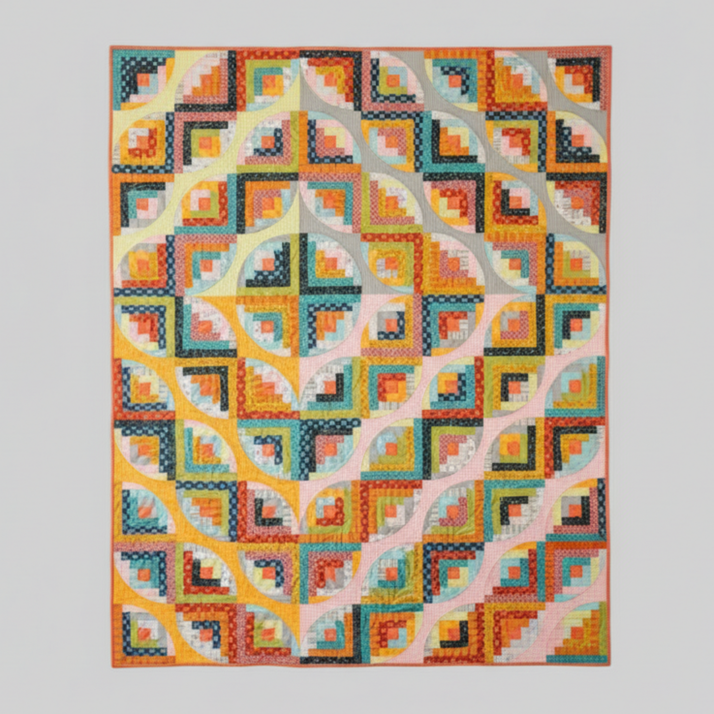 Colorful geometric quilt on a wall with a wooden chair and vase of flowers below.