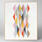 Framed geometric quilt with colorful diamond patterns on a white background