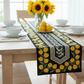 Table setting with a decorative table runner featuring yellow tulips on a wooden table.