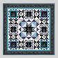 Quilt with geometric pattern featuring squares and triangles in black, white, and blue on a gray background