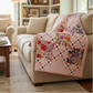 Floral quilt draped over a beige sofa in a living room setting.