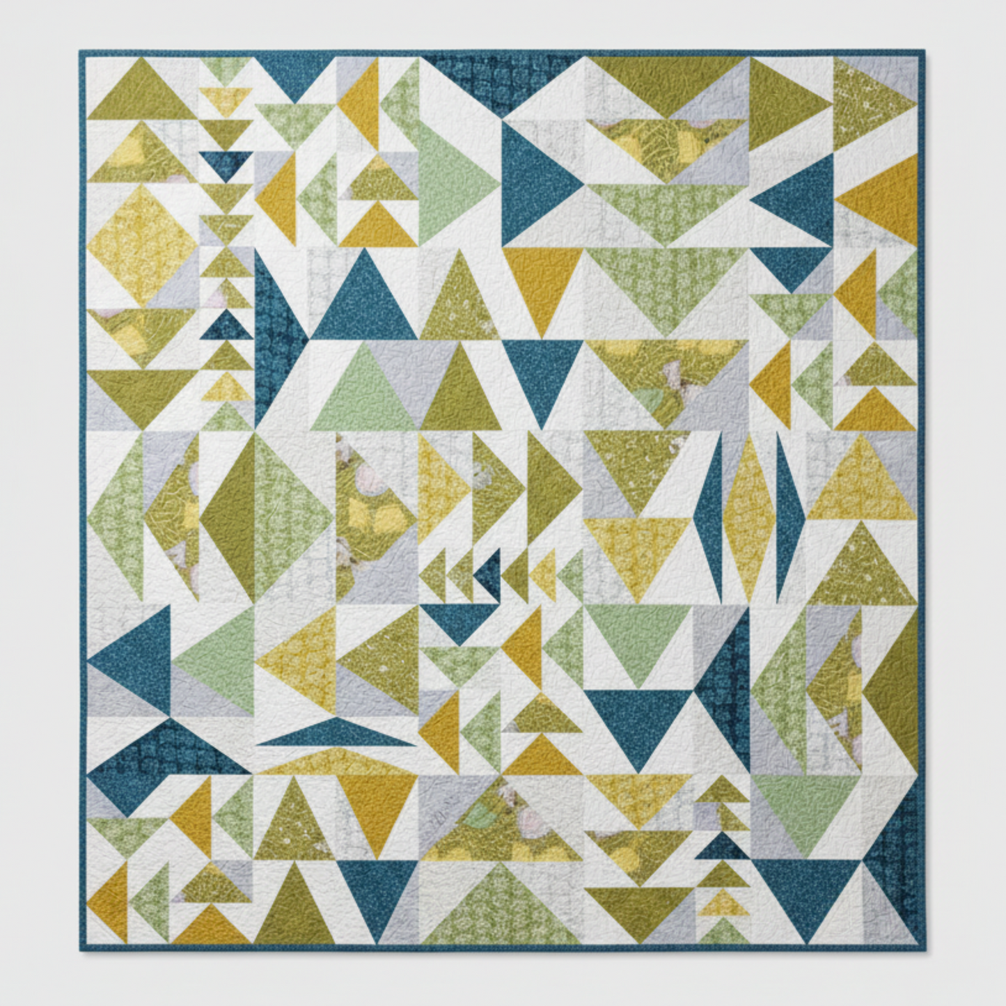 Geometric triangle pattern quilt with blue, green, and yellow colors on a white background