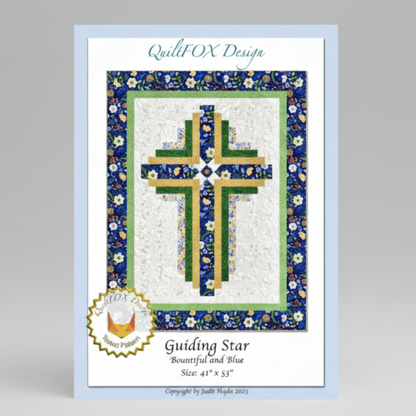 Quilt pattern cover with a cross design and floral border, featuring 'QuiltFOX Design' branding.