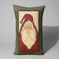 Decorative pillow with a Santa Claus design on a wooden surface.