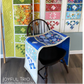 Quilt displayed on a chair with fabric samples in the background
