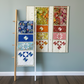 Three quilt panels displayed on a ladder against a white wall with 'Joyful Trio' and 'Robin Pickens.com' text.