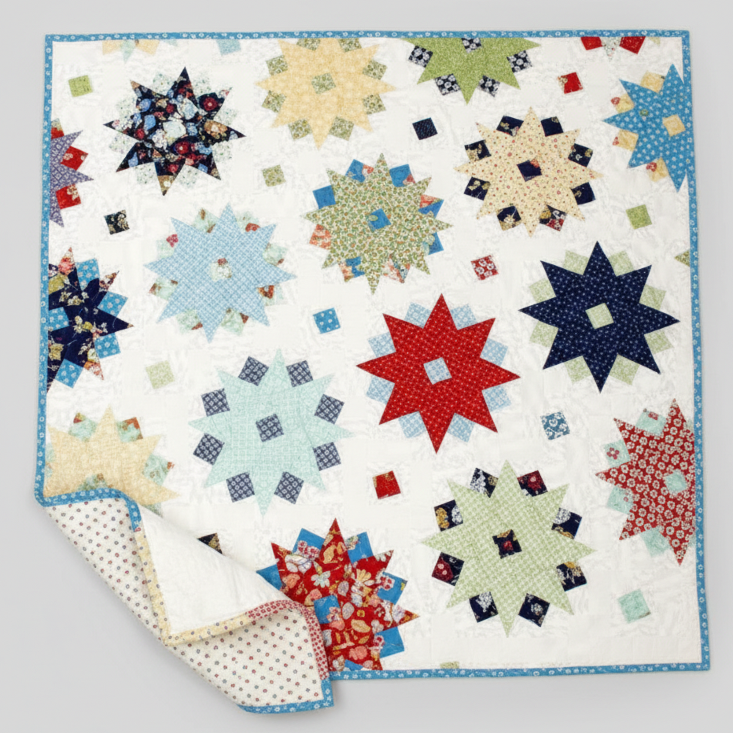 Colorful star-shaped patchwork quilt on a white background