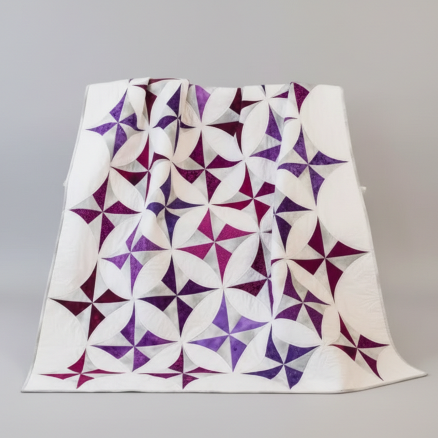Quilt with purple and white star pattern draped over a chair, Shabby Fabrics logo visible