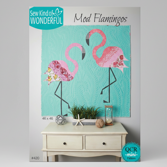 Flamingo-themed quilt with decorative elements on a table