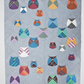 Quilt with colorful owl patterns on a gray background