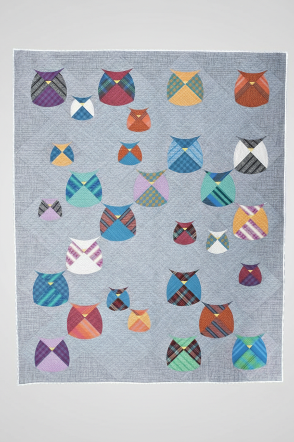 Quilt with colorful owl patterns on a gray background