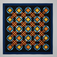 Colorful quilt with geometric pattern on a gray background