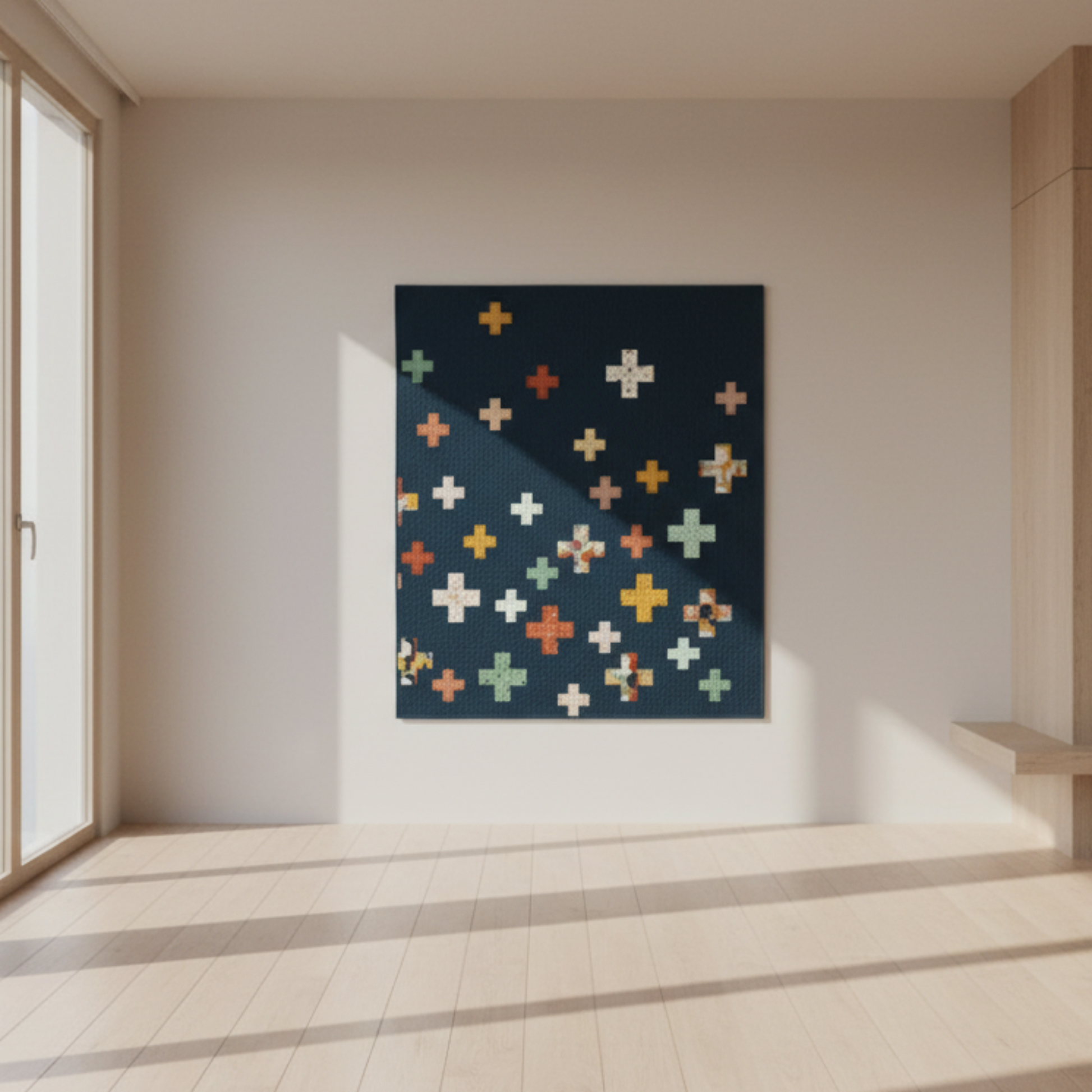 Colorful cross-patterned  quilt on a wall in a minimalistic room with light wood flooring and sliding glass door.
