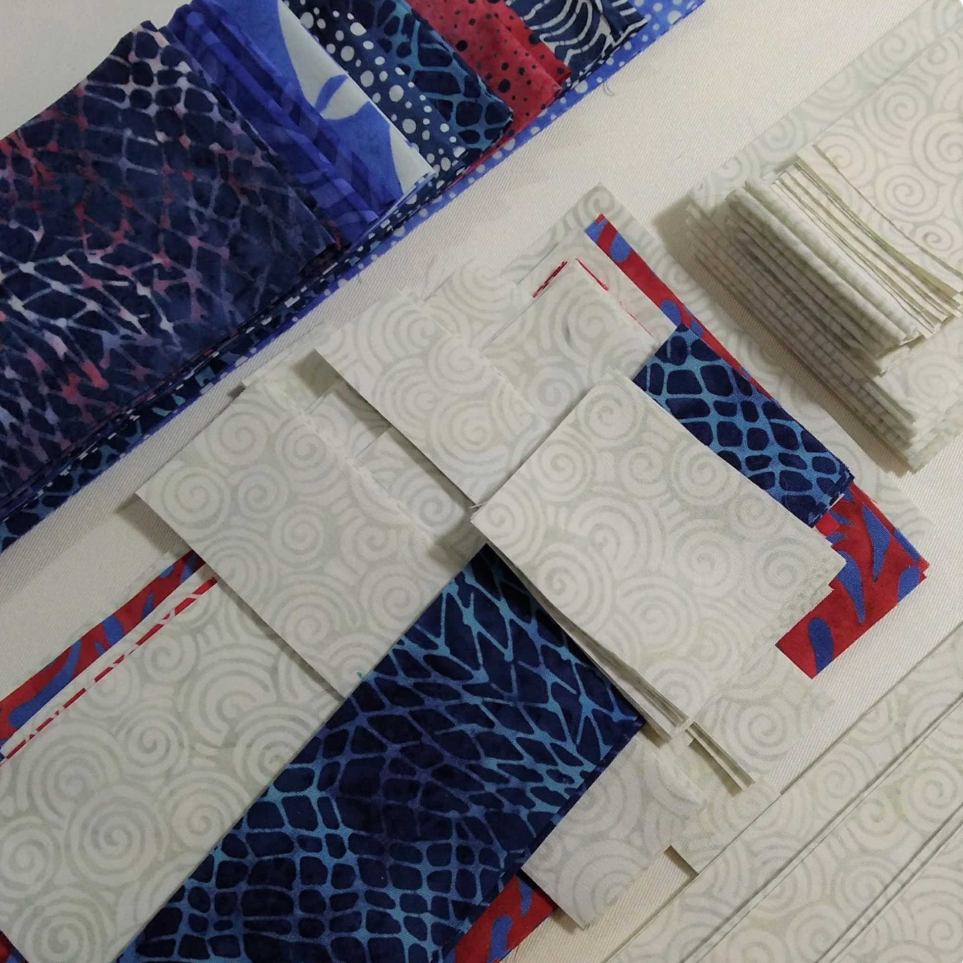 Fabric swatches with blue, red, and white patterns on a white background