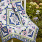 Quilt with floral patterns and geometric designs on a white background