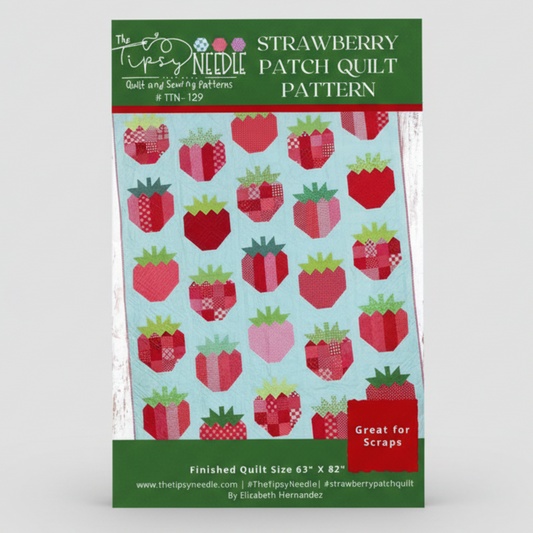Strawberry patch quilt pattern packaging with red and green strawberries on a light blue background.