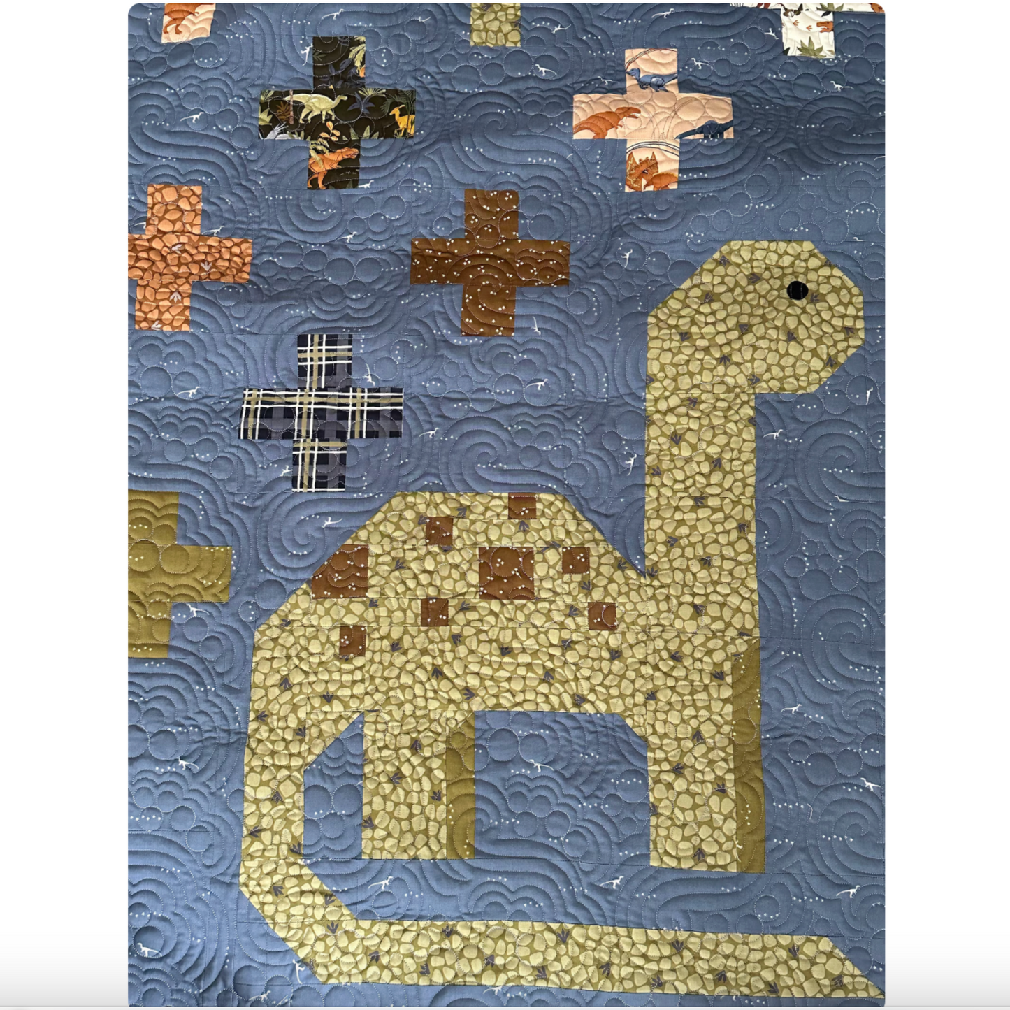 Quilt with a dinosaur design on a blue background